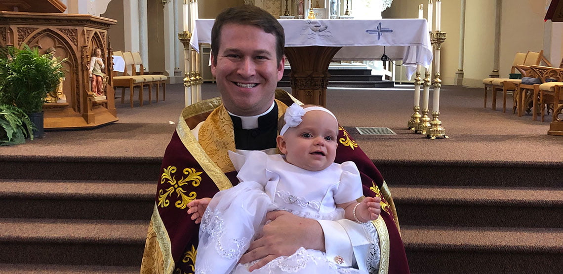 Fr. Arisman at Baptism With Baby