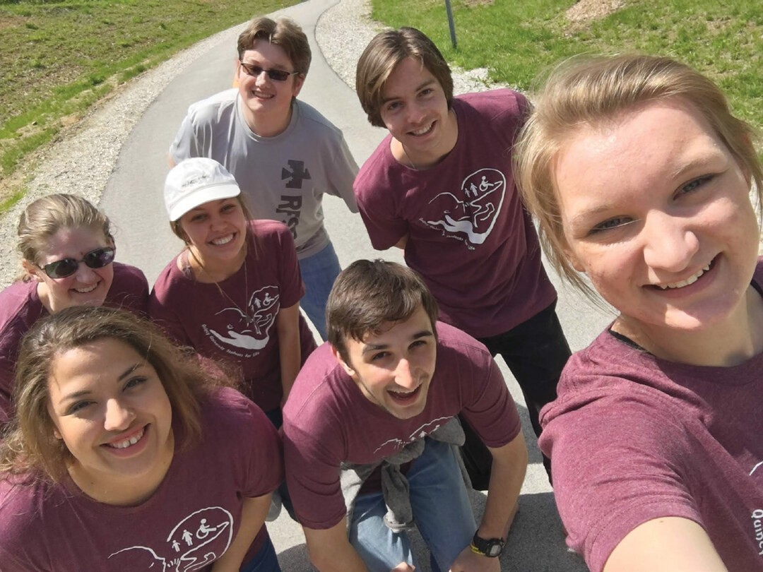 Lydia (front right corner) and David Spillman (middle of group) take a walk on Bob Mays trail with members of the Quincy University Students for Life after participating in the Dogwood parade, May 2018.